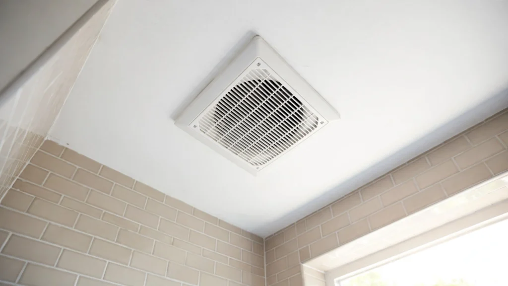 White bathroom ceiling exhaust fan vent cover in a bright modern bathroom